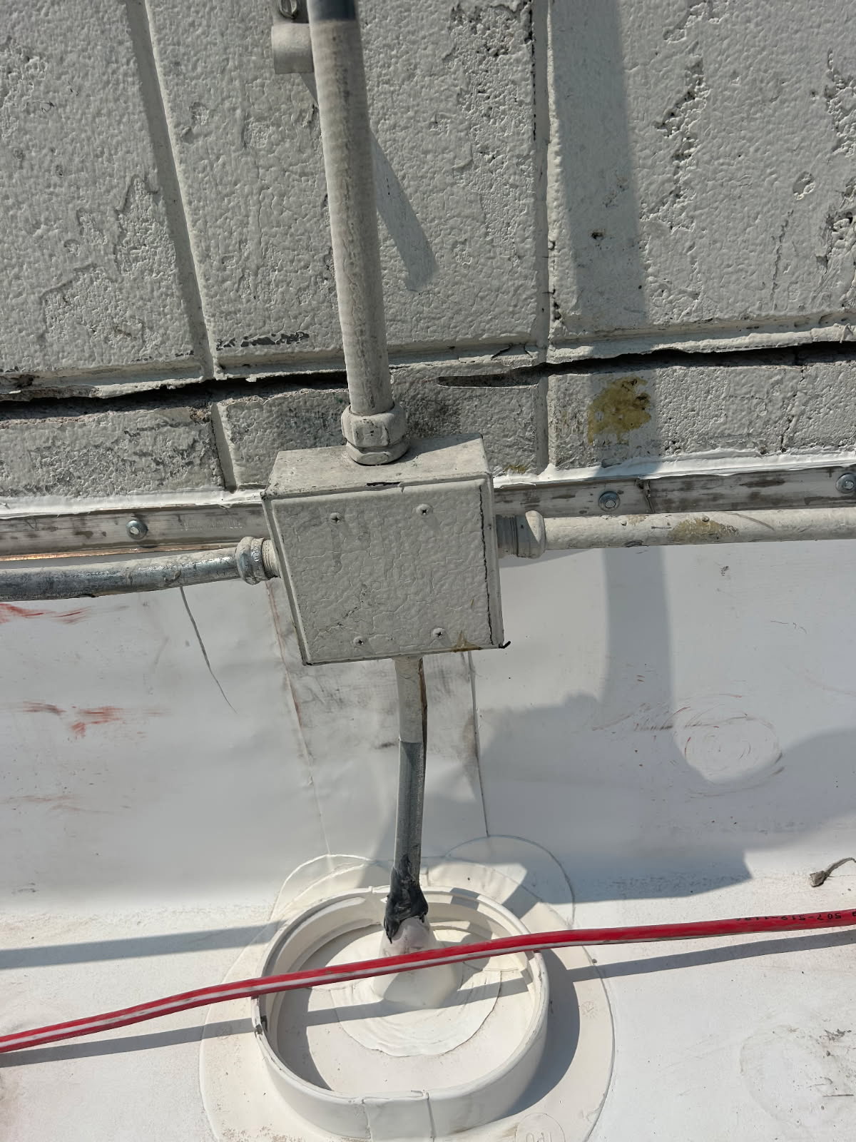 Electrical junction box with conduit on rooftop wall
