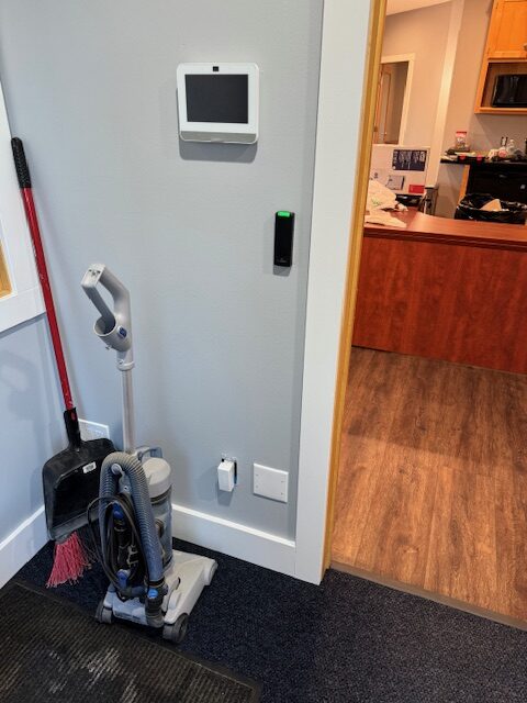 Vacuum and cleaning tools near wall with control panel