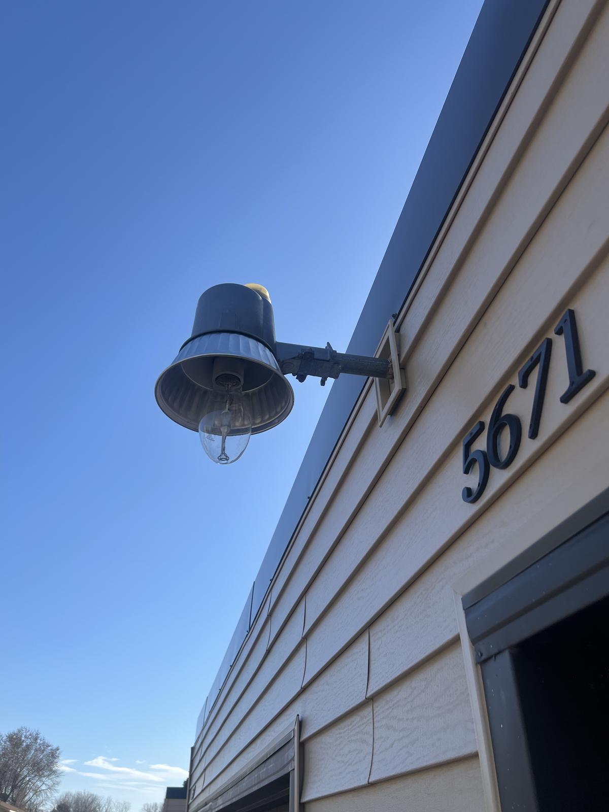 Outdoor wall light fixture above door with number 5671